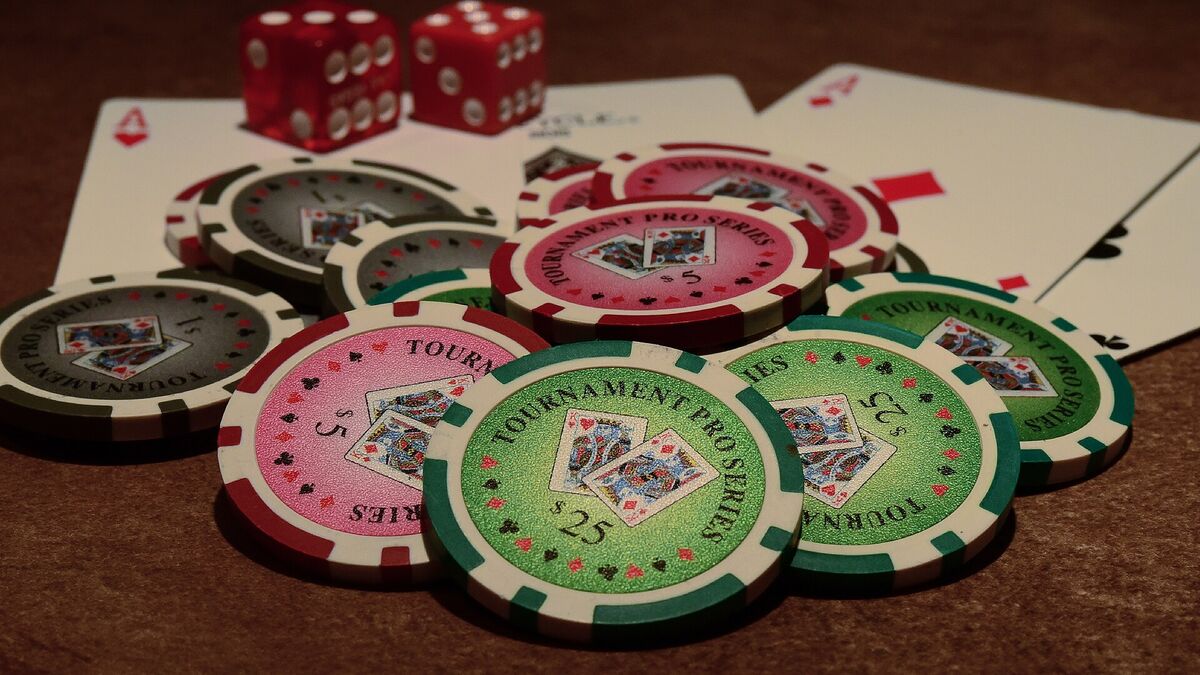 Poker chips stacked beside playing cards and dice