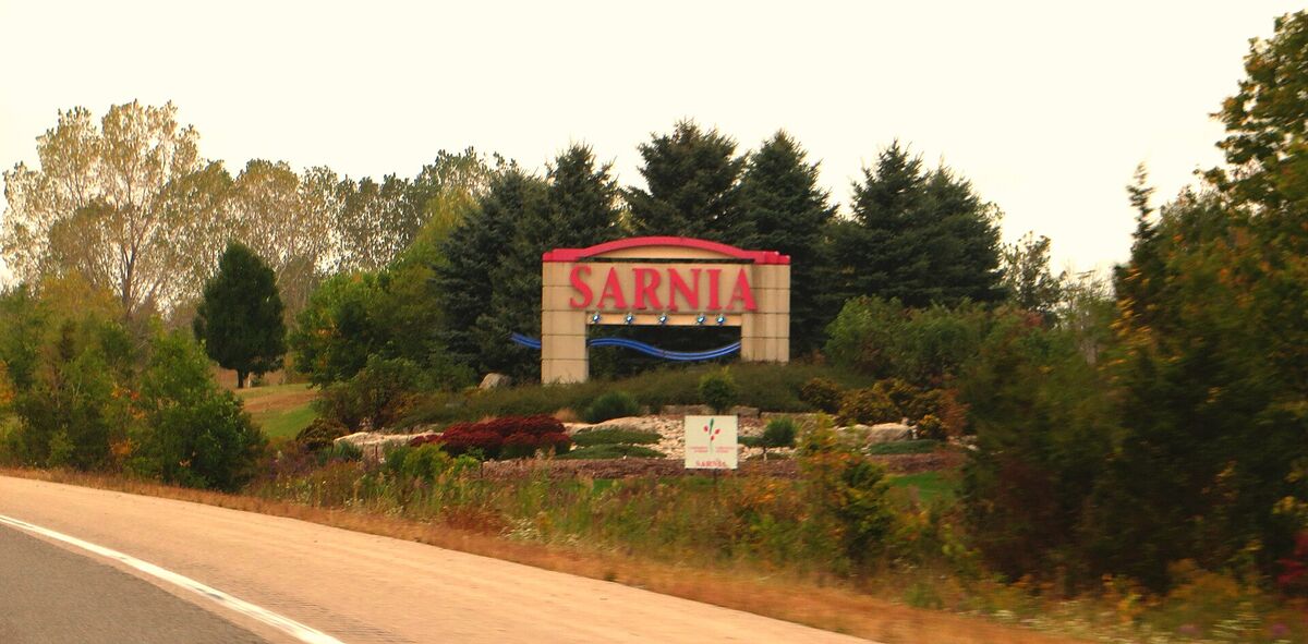 Roadside Sarnia welcome sign surrounded by trees and landscaped gardens